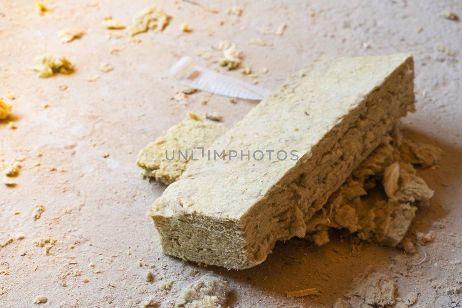 Scraps of mineral wool insulation sheet lie on the floor
