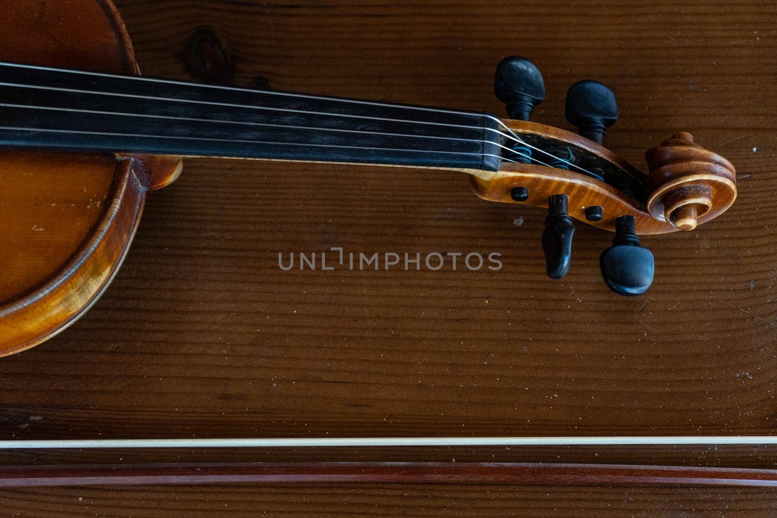 Part of a violin on a brown background. Violin handle