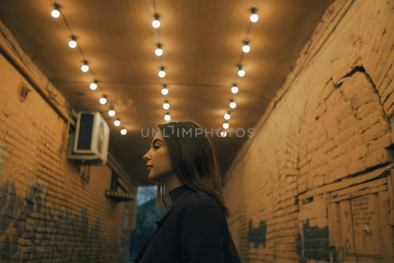 portrait of a woman in a lantern-lit alley late in the evening