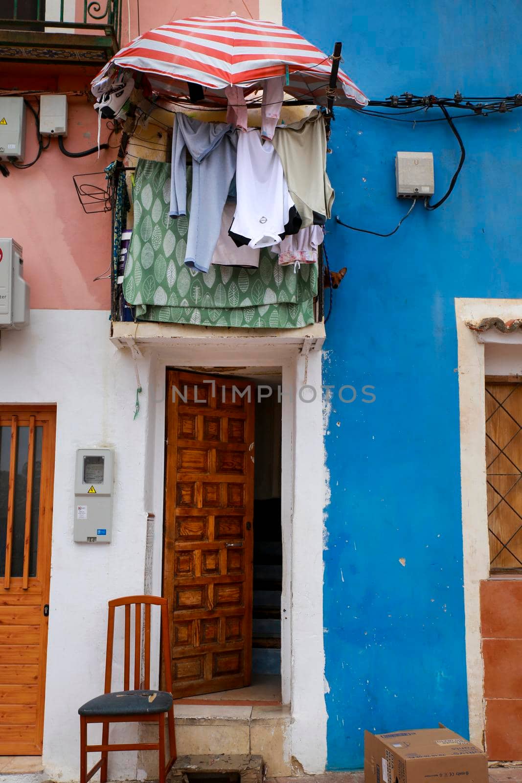 Villajoyosa, Alicante, Spain- April 22, 2022:Old colorful facades with hanging clothes in Villajoyosa, Alicante, Spain