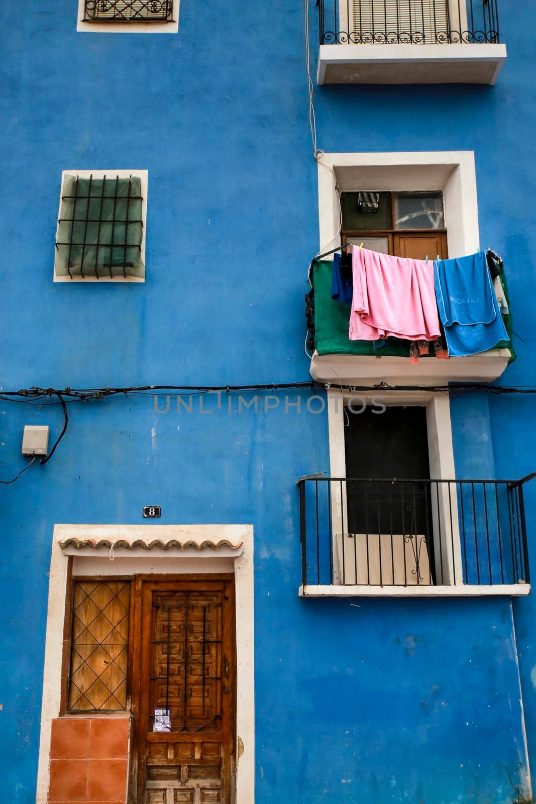 Colorful facades with hanging clothes in Villajoyosa town by soniabonet