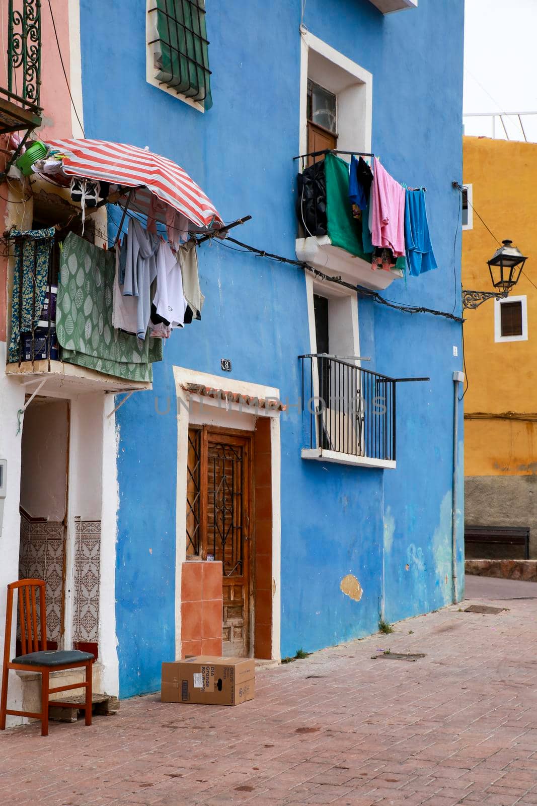 Villajoyosa, Alicante, Spain- April 22, 2022:Old colorful facades with hanging clothes in Villajoyosa, Alicante, Spain