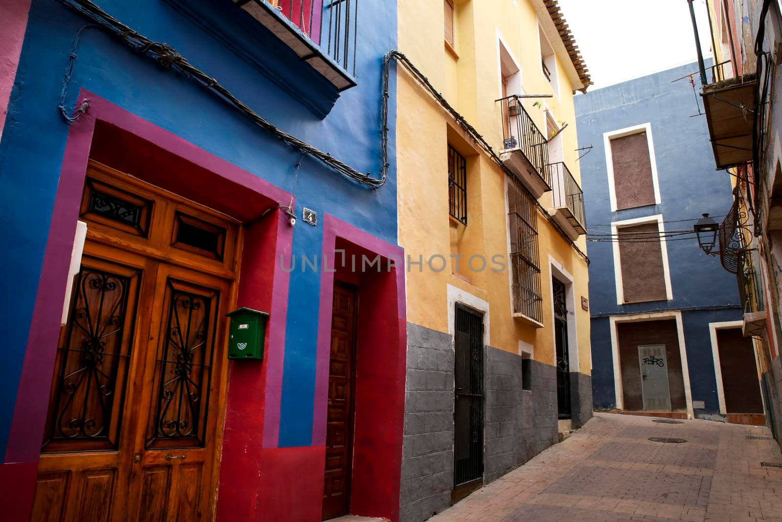 Villajoyosa, Alicante, Spain- April 22, 2022:Narrow cobbled street and beautiful colorful facades in Villajoyosa village, Alicante, Spain