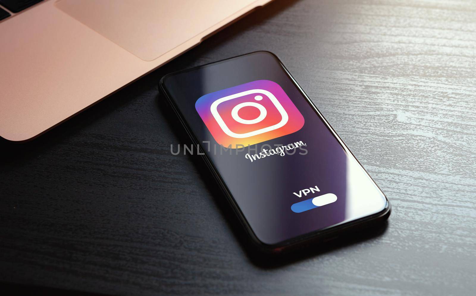 MOSCOW, RUSSIA - MAY 03, 2022: iphone lying on a wooden table, on the screen Instagram social application logo, which starts only after turning on the vpn connection. Government censorship concept.