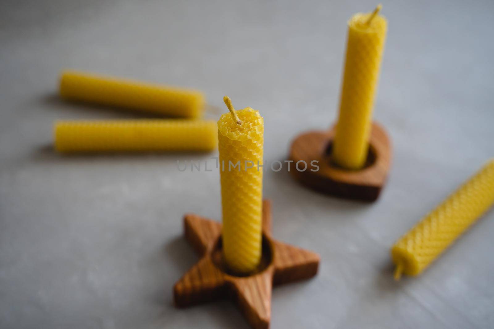 Honey candles in wooden candlesticks. Natural and eco-friendly material. A set of honey candles. Wooden candle holder in the form of an asterisk.