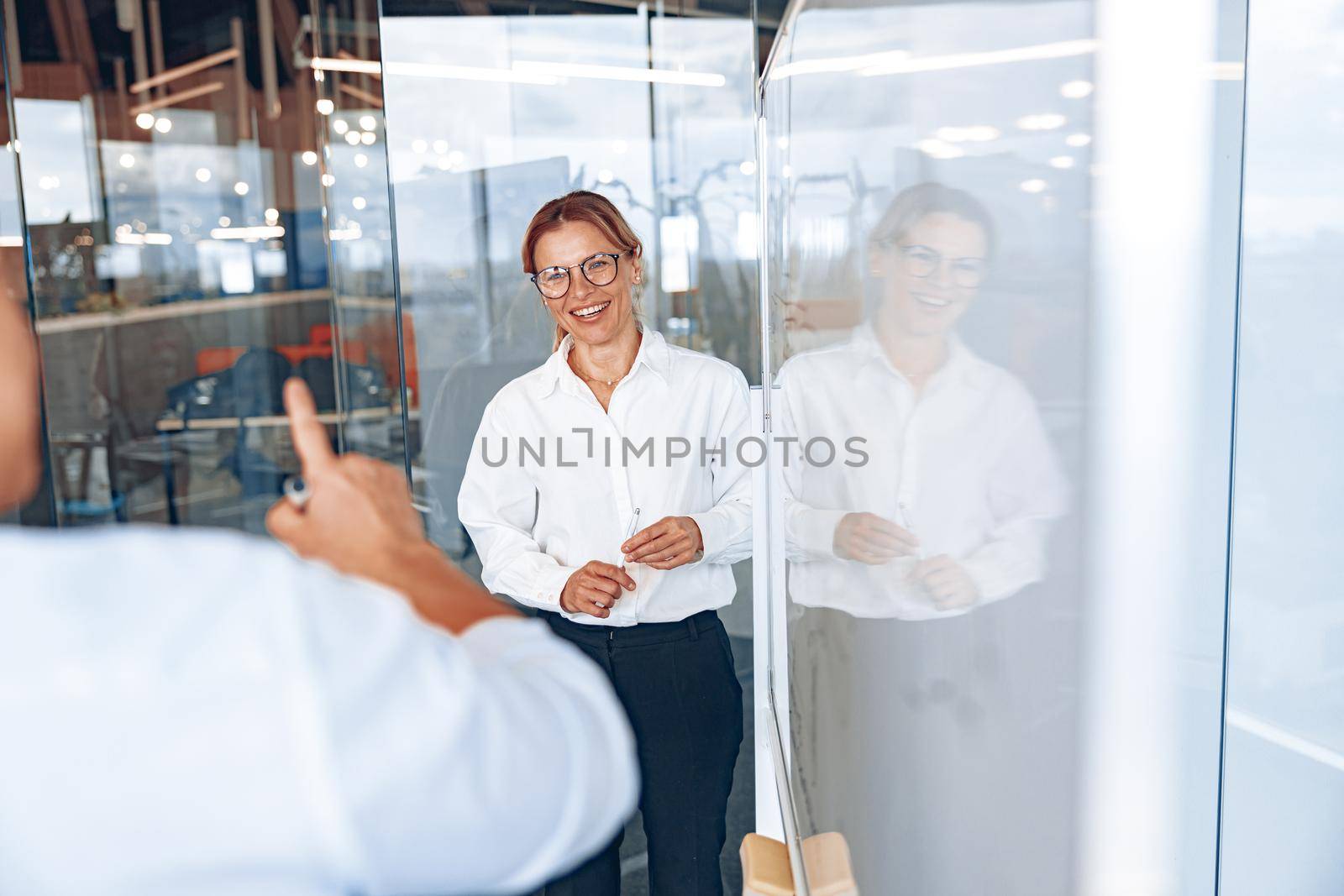 Successful smiling lady boss listens to employee's comments during business meeting by Yaroslav_astakhov