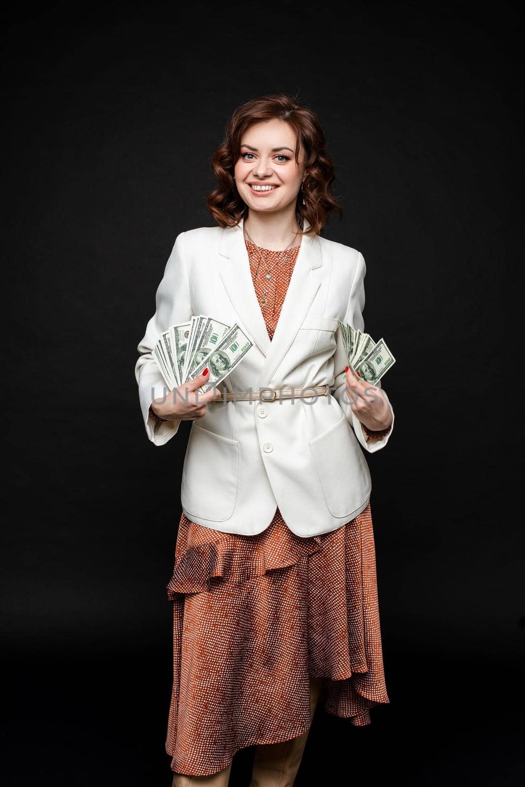 Cute young girl shows a lot of money in the hands, picture isolated on black background by StudioLucky