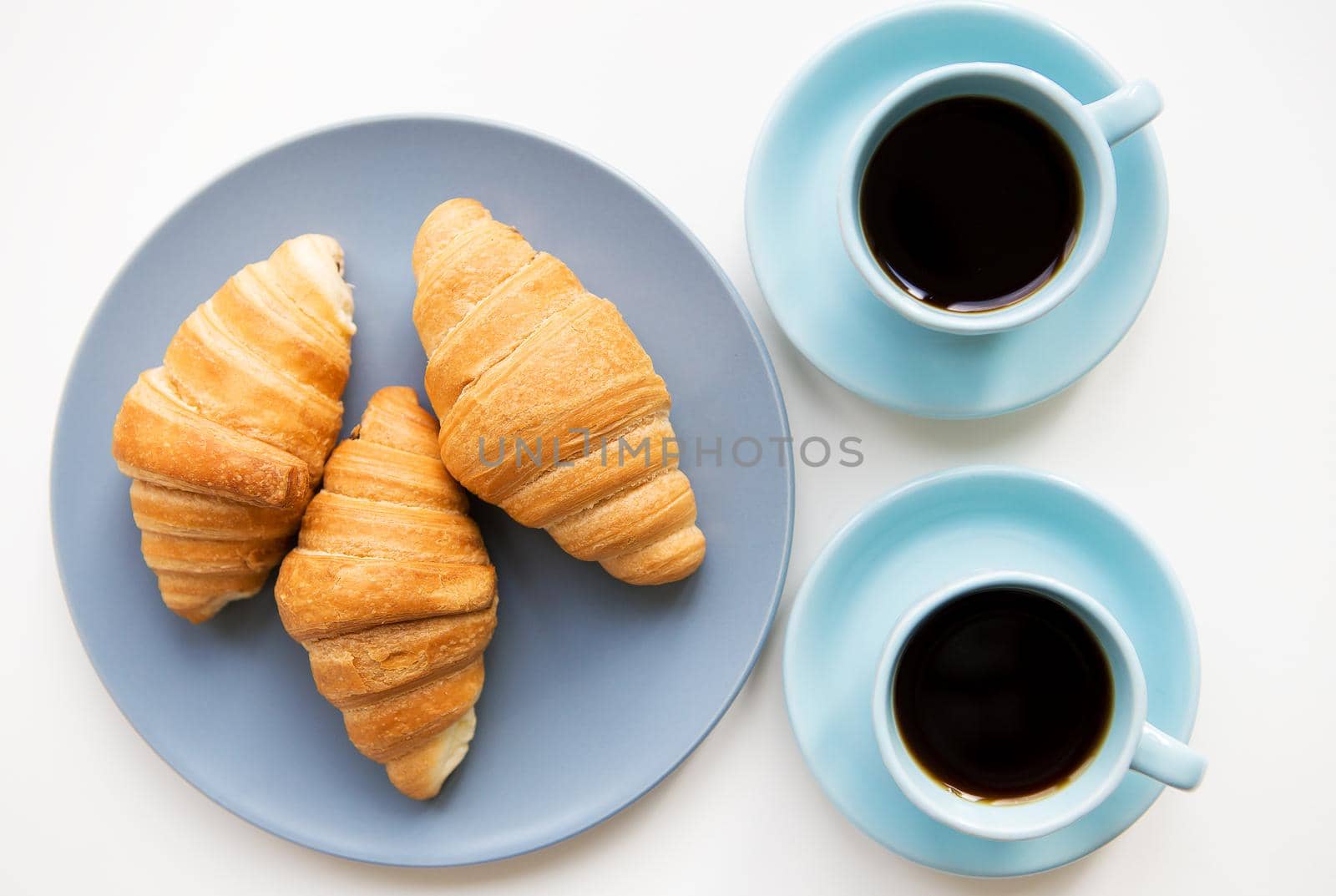 cup of coffee with croissant on white background