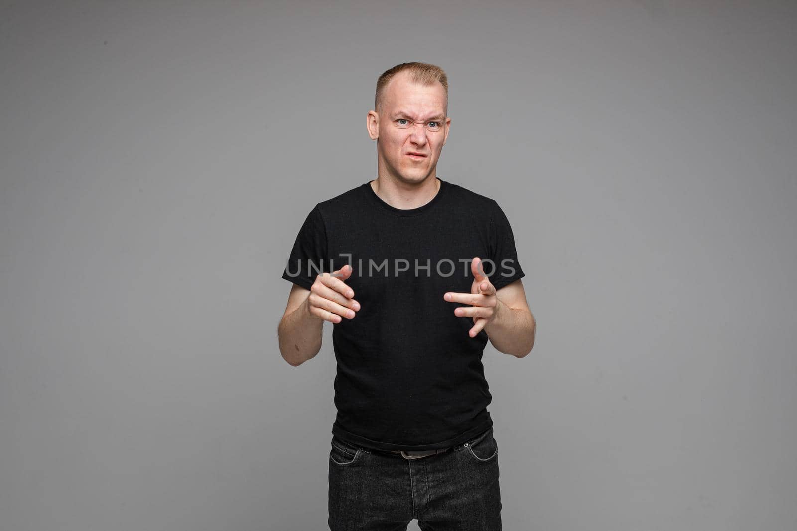 picture of caucasian man keeps his hands near the head rages isolated on grey background