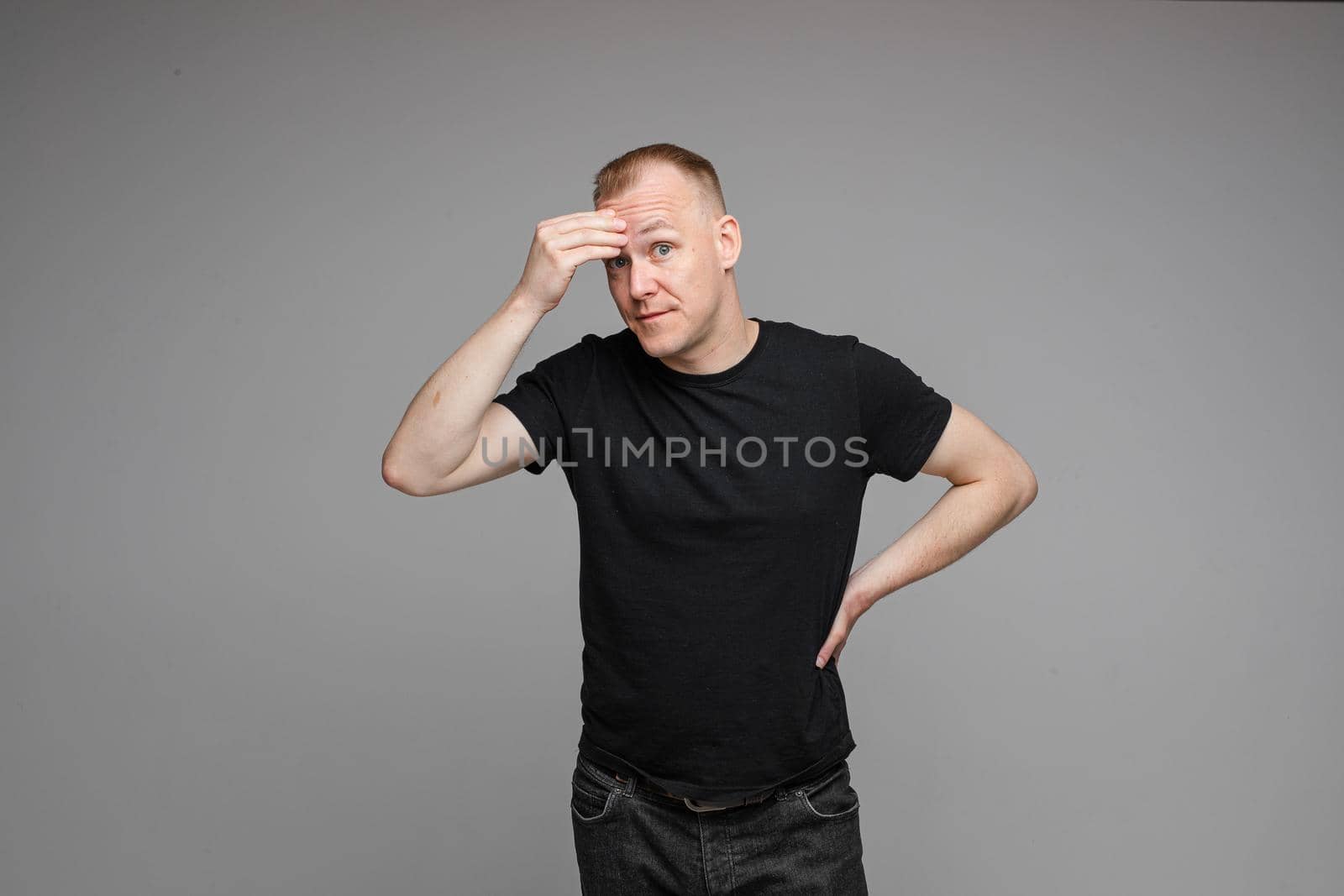 picture of caucasian male wearing a t-shirt and jeans isolated over the grey background