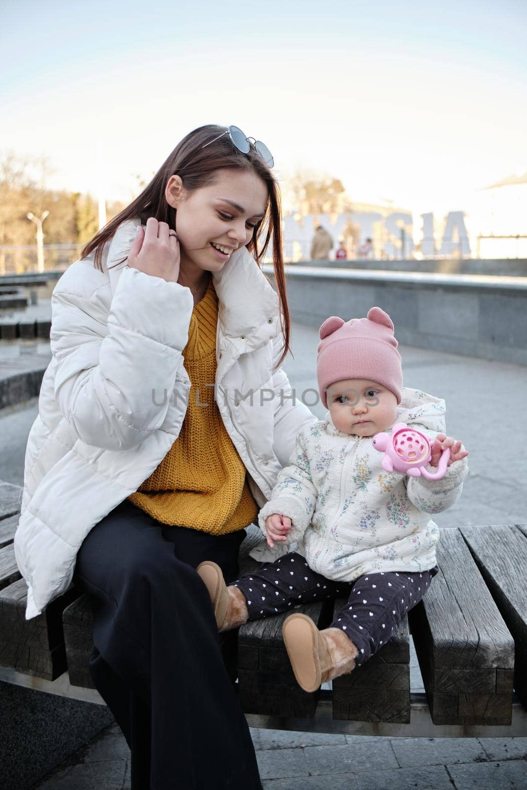 Young mother with her cute baby on bench by Symonenko