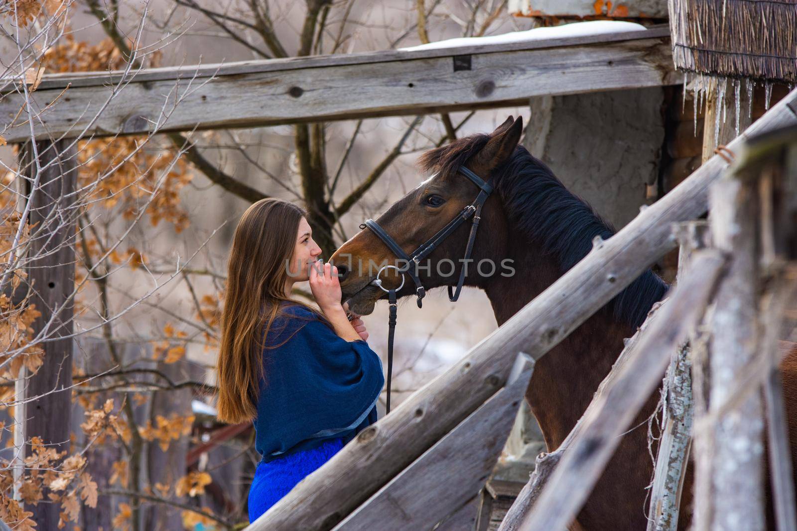 Portrait of a happy girl hugging a horse, the girl joyfully looks at the horse a