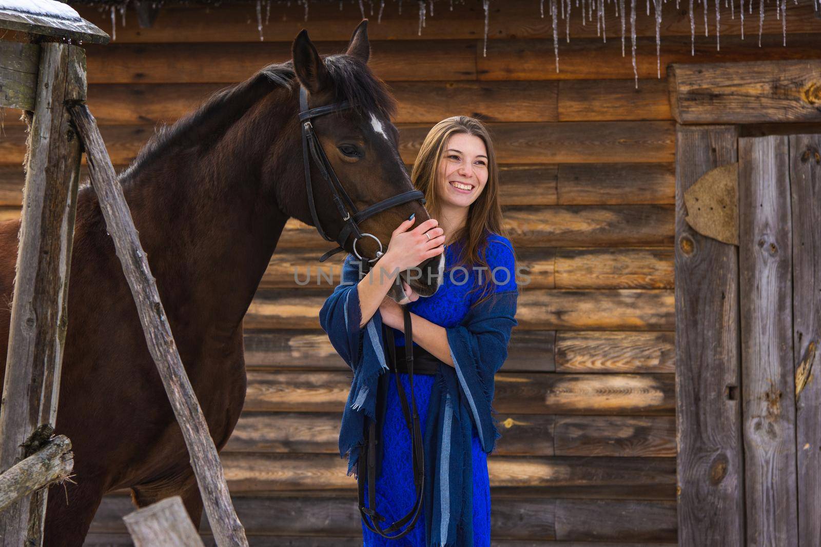 Happy girl hugging a horse and looking into the distance a
