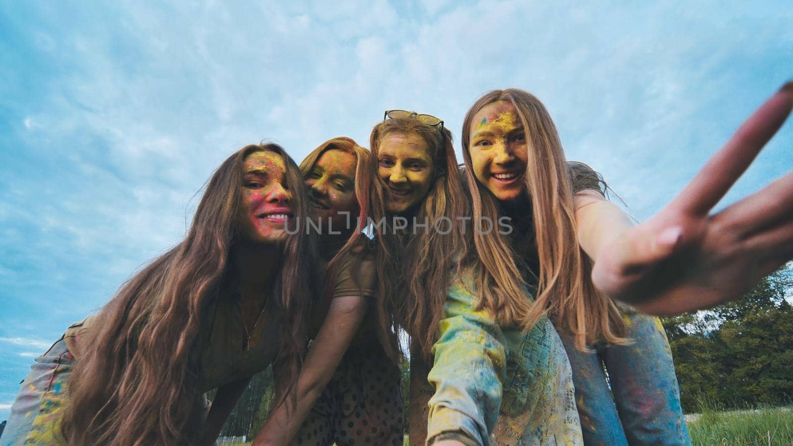 Cheerful girls are posing smeared in multi-colored powder. by DovidPro