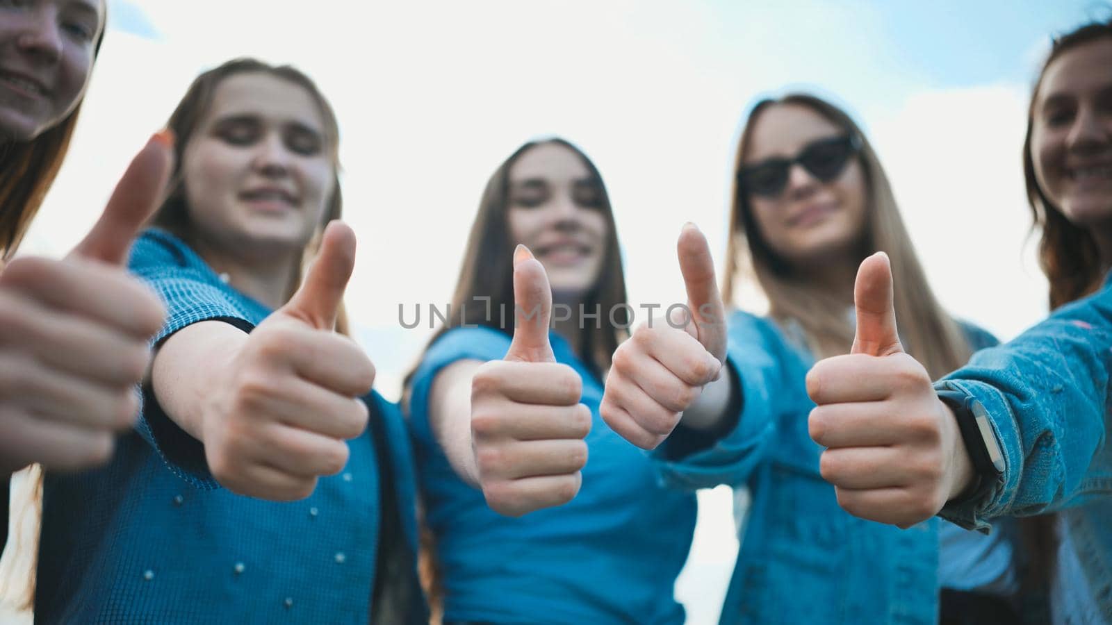 A group of girls girlfriends show thumbs up. by DovidPro