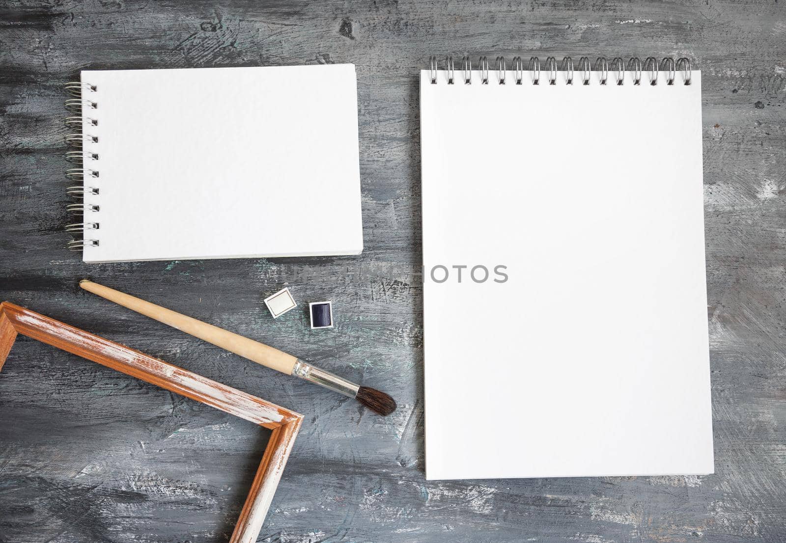 Artistic notepads with empty pages on black wood table background for portfolio design