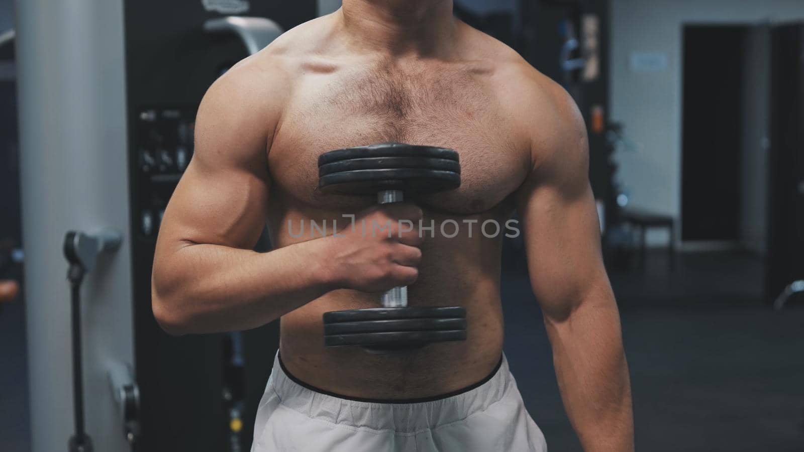 Muscular arab man training with dumbbells in the gym. by DovidPro