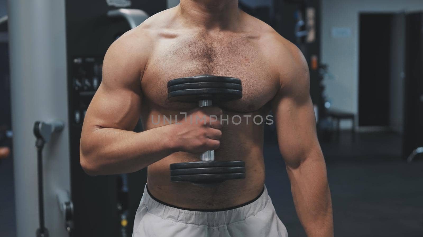 Muscular arab man training with dumbbells in the gym