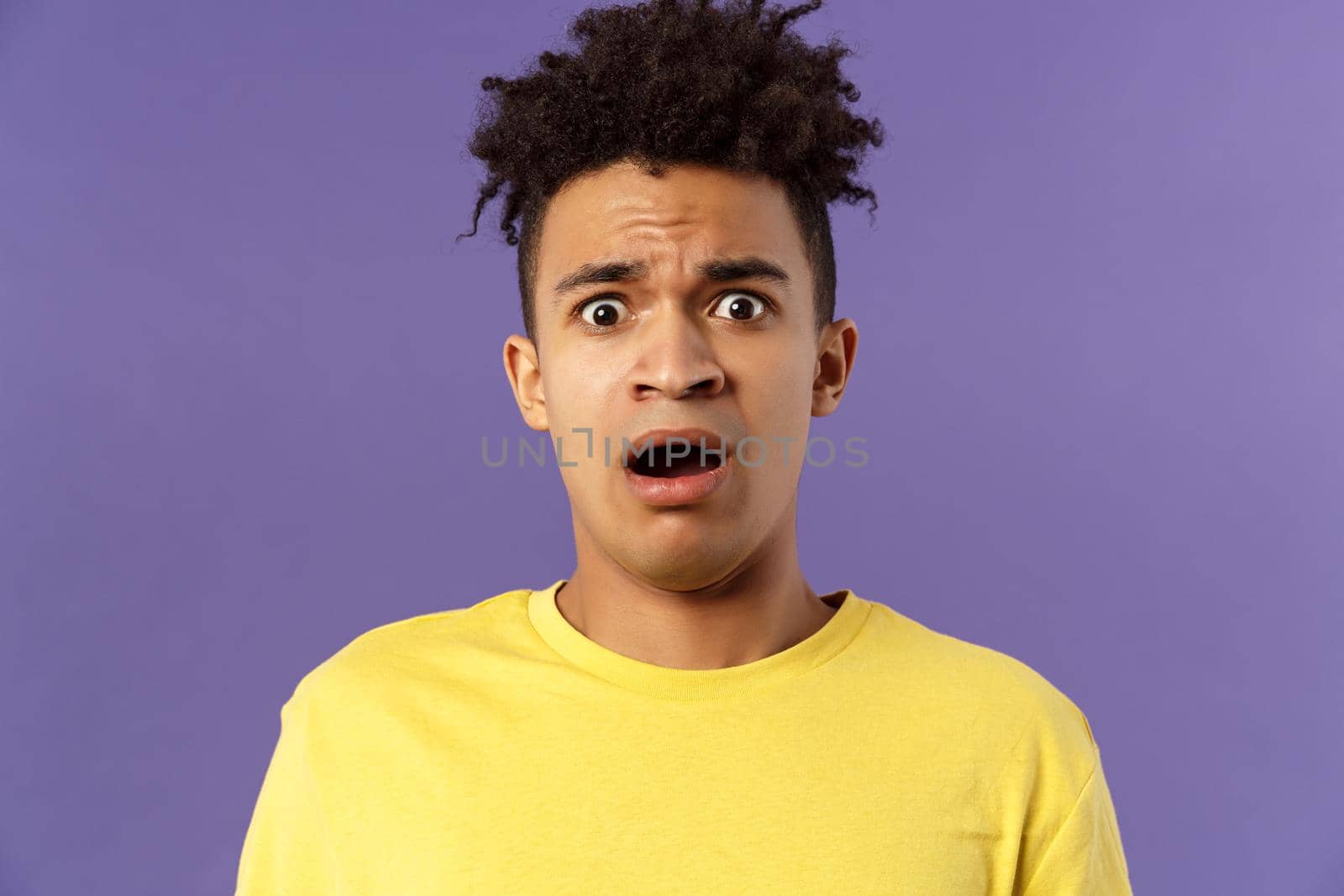 Close-up portrait of shocked, alarmed young man gasping, open mouth scared and frightened, staring camera concerned, facing troublesome shocking news, purple background by Benzoix