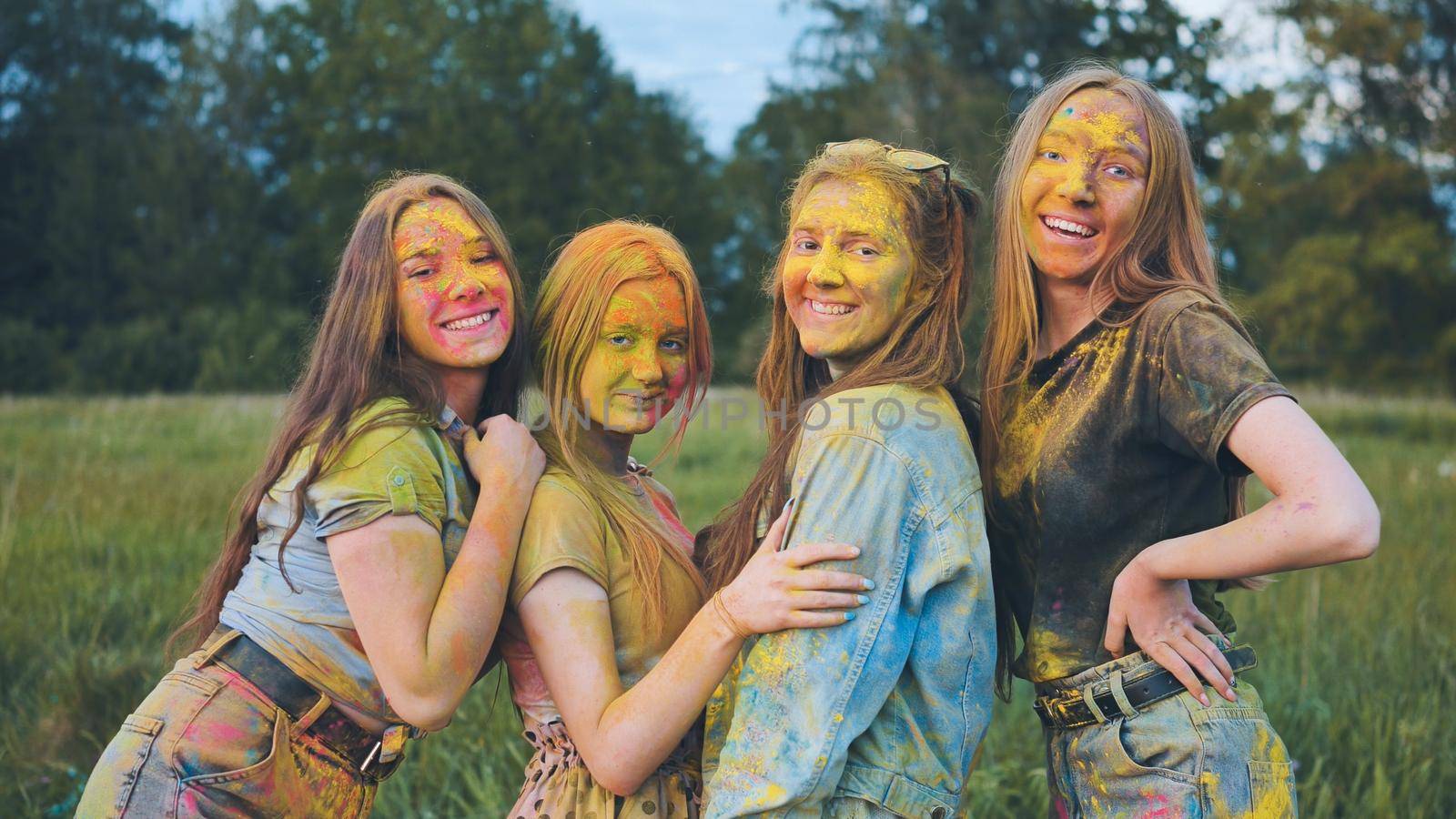 Cheerful girls posing smeared in multi-colored powder