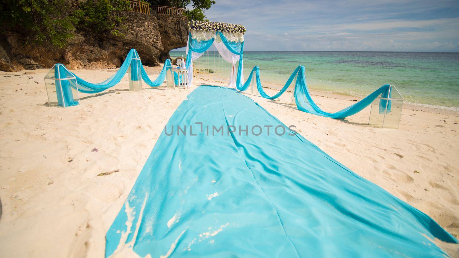 Wedding arch decorated with flowers on the beach near the ocean