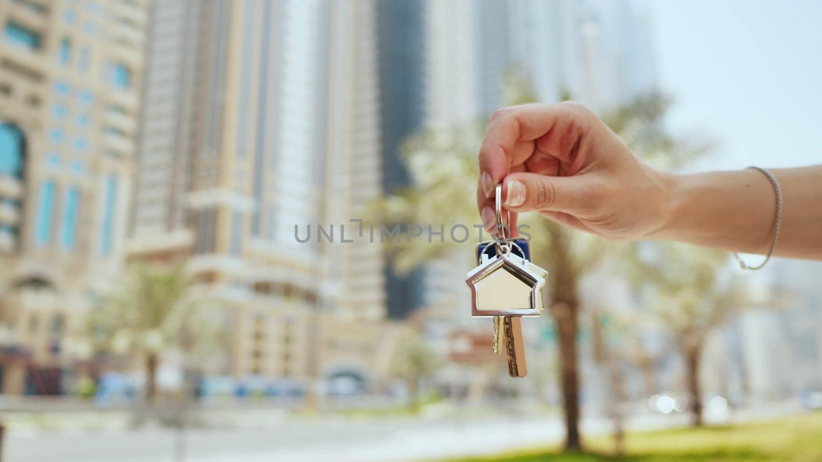 Hand girl holds the keys. The concept of buying an apartment or car in Dubai. Hand close-up