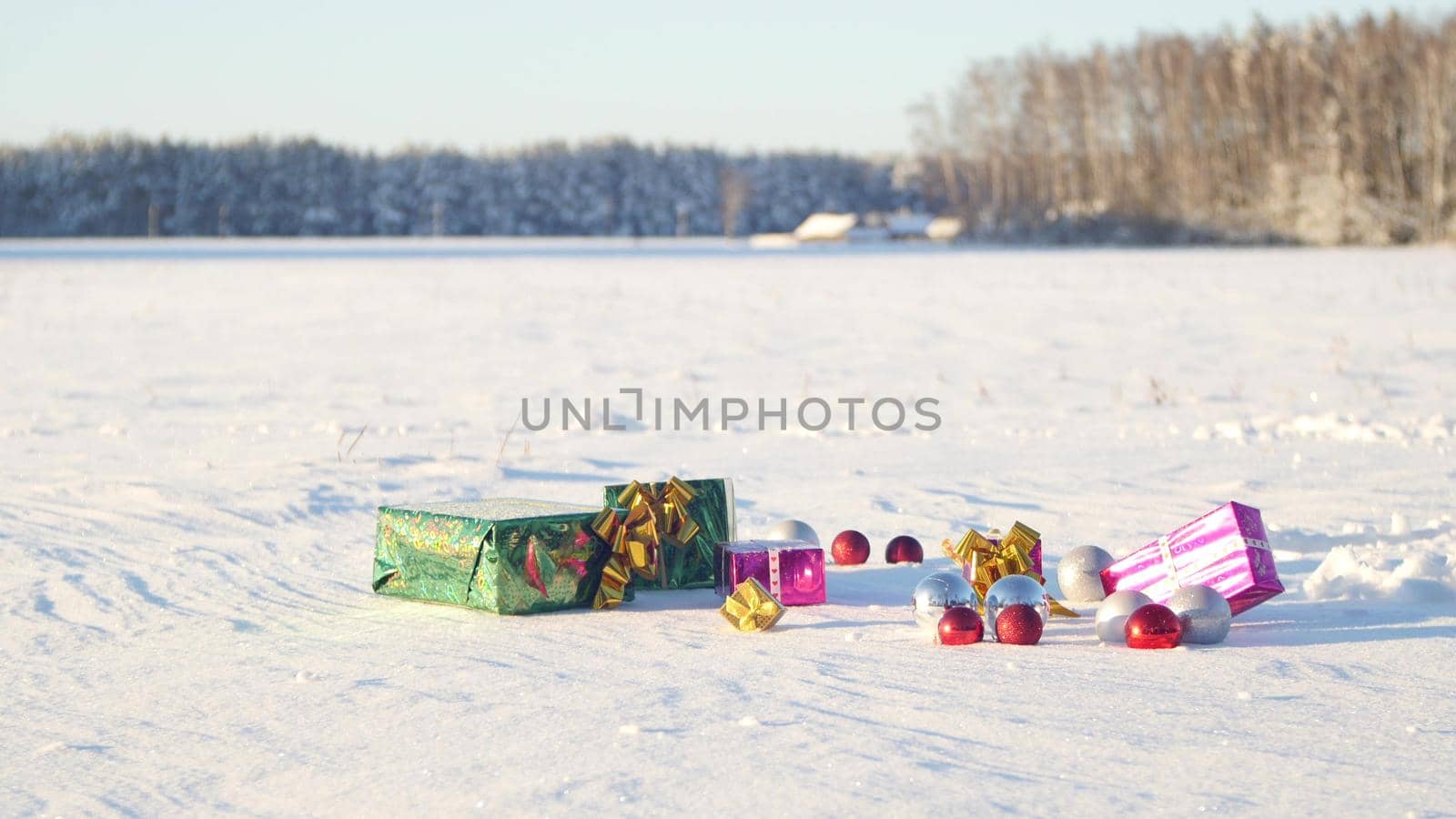 Christmas gifts in a field on snow in a sunny, frosty and clear weather outdoors