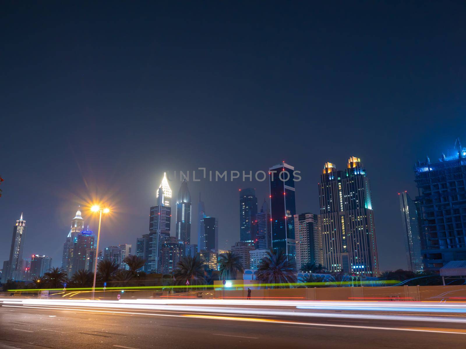 Dubai skyscrapers at night with road traffic late at night