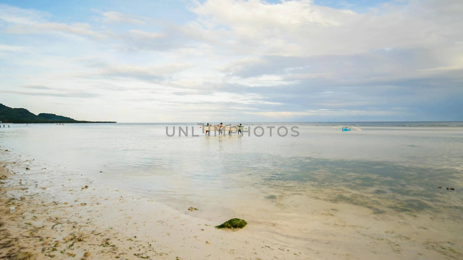 Fishermen carry a boat to the sea. Bohol Island. Philippines. by DovidPro