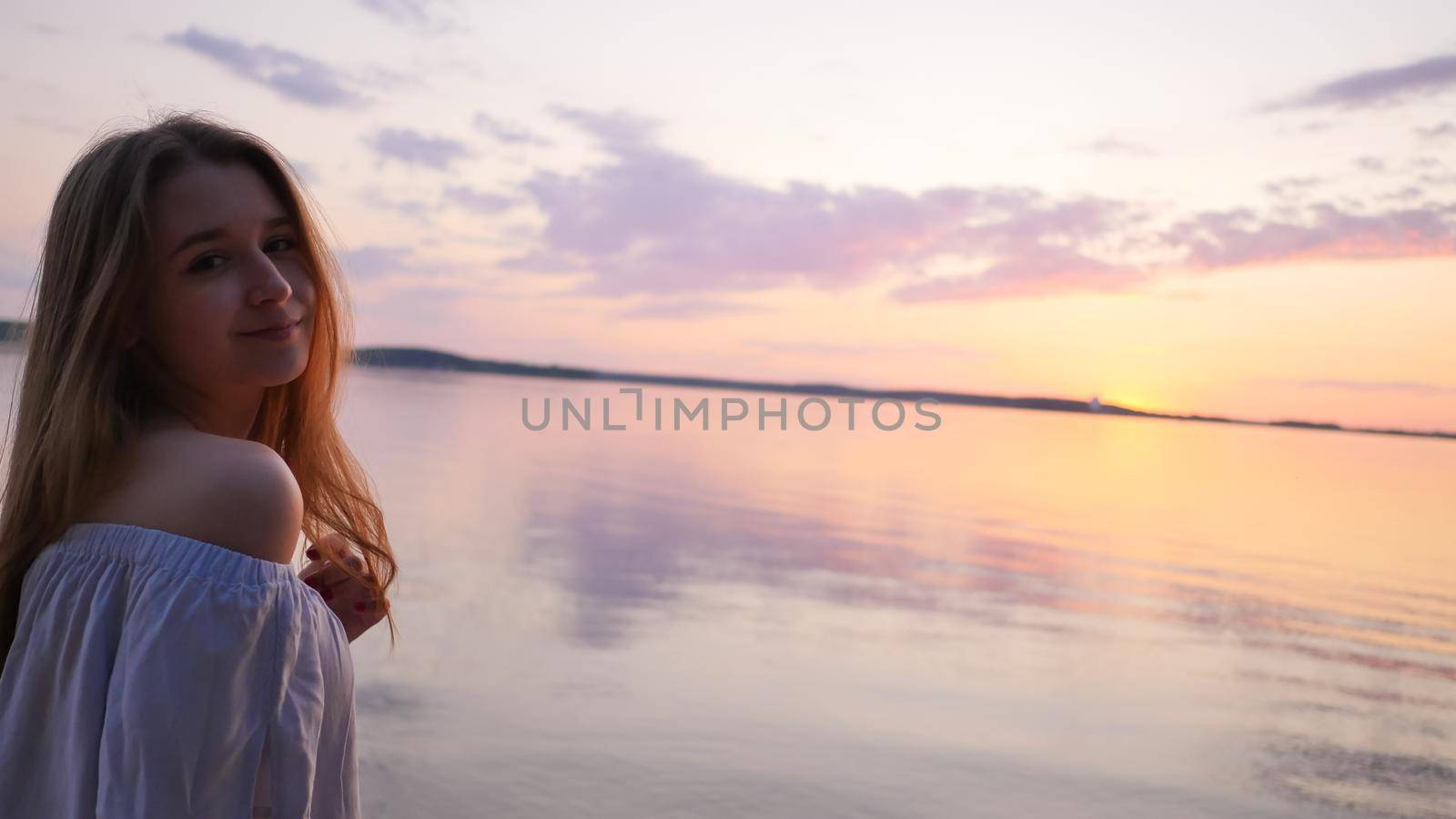 Young girl on the background of the sea and sunset. by DovidPro