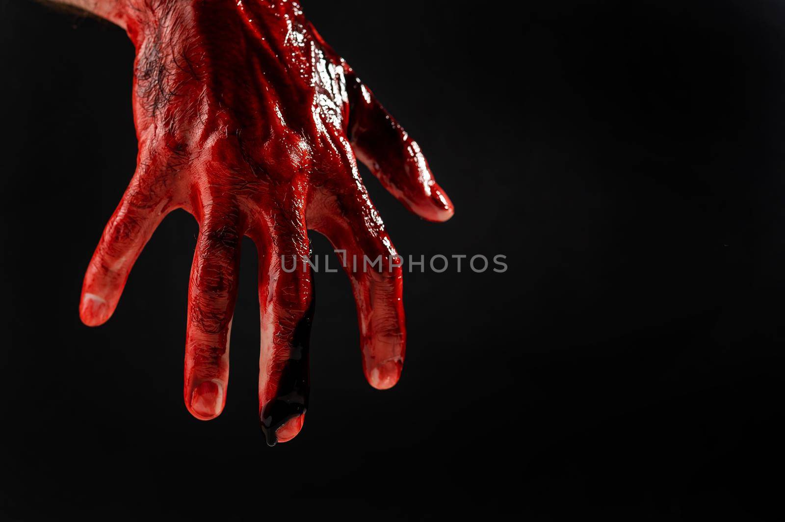 Close-up of a male hand stained with blood on a black background. by mrwed54
