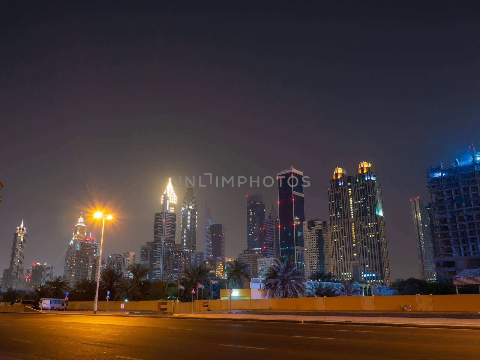 Dubai skyscrapers at night with road at night. by DovidPro