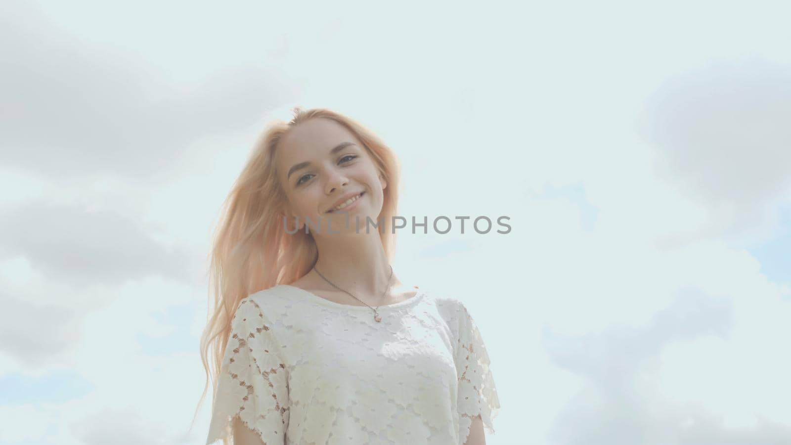 Young Russian girl blonde posing against a white sky on a summer day. by DovidPro