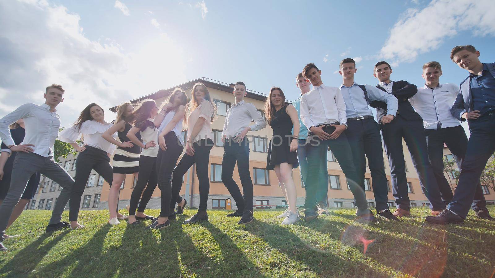 Posing of high school students against the background of his school. Russian schoolchildren. Shooting in motion