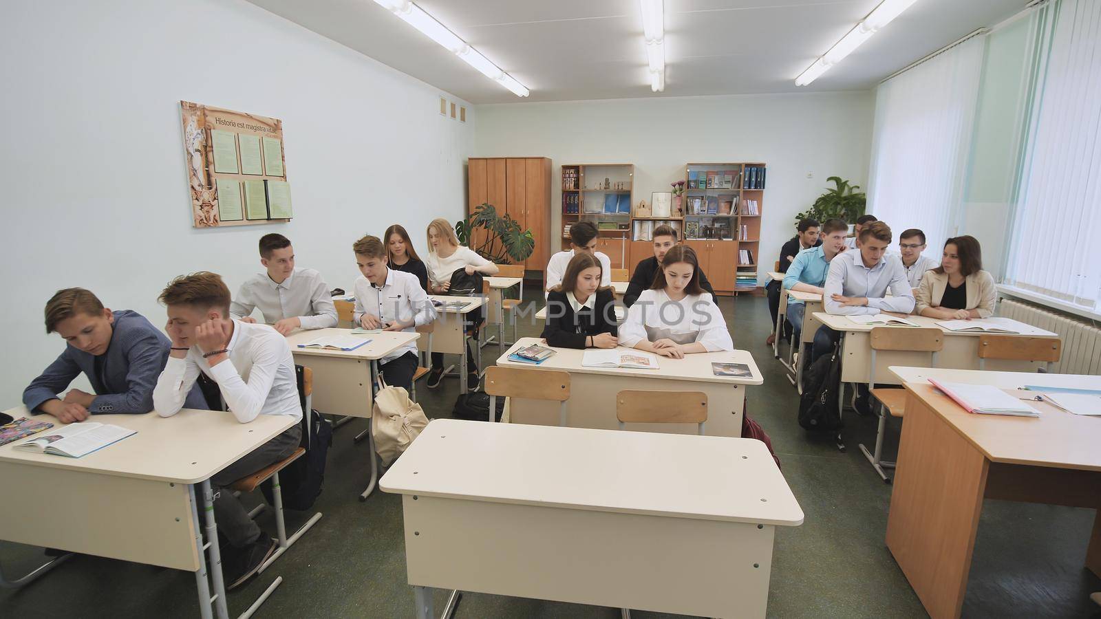 Students in the classroom sit at school desks before the lesson. Russian school