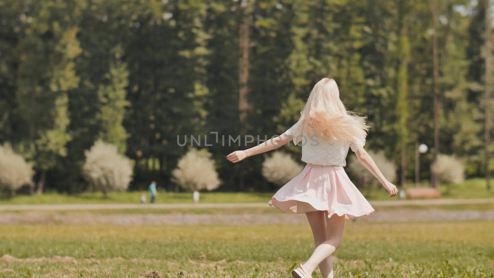 A happy young russian girl is running in the city park. by DovidPro