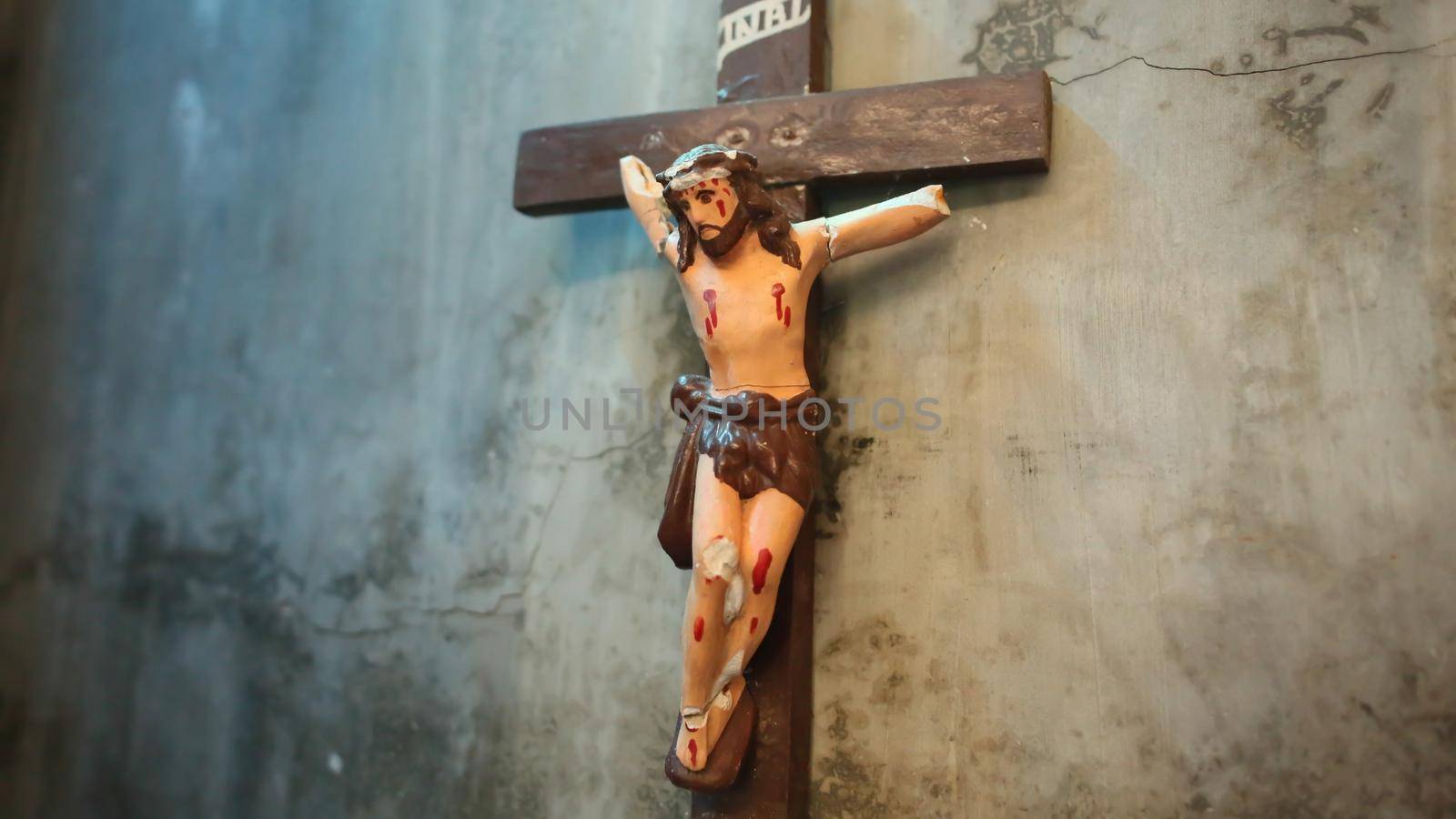 The old and the broken crucify Christ hanging on the old wall. by DovidPro