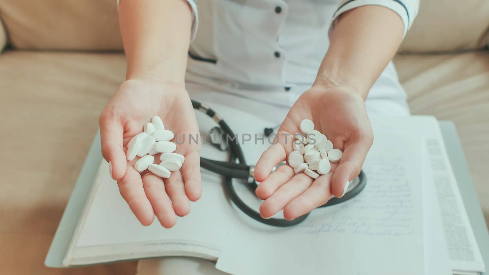 A young girl doctor poured white pills from hand to hand