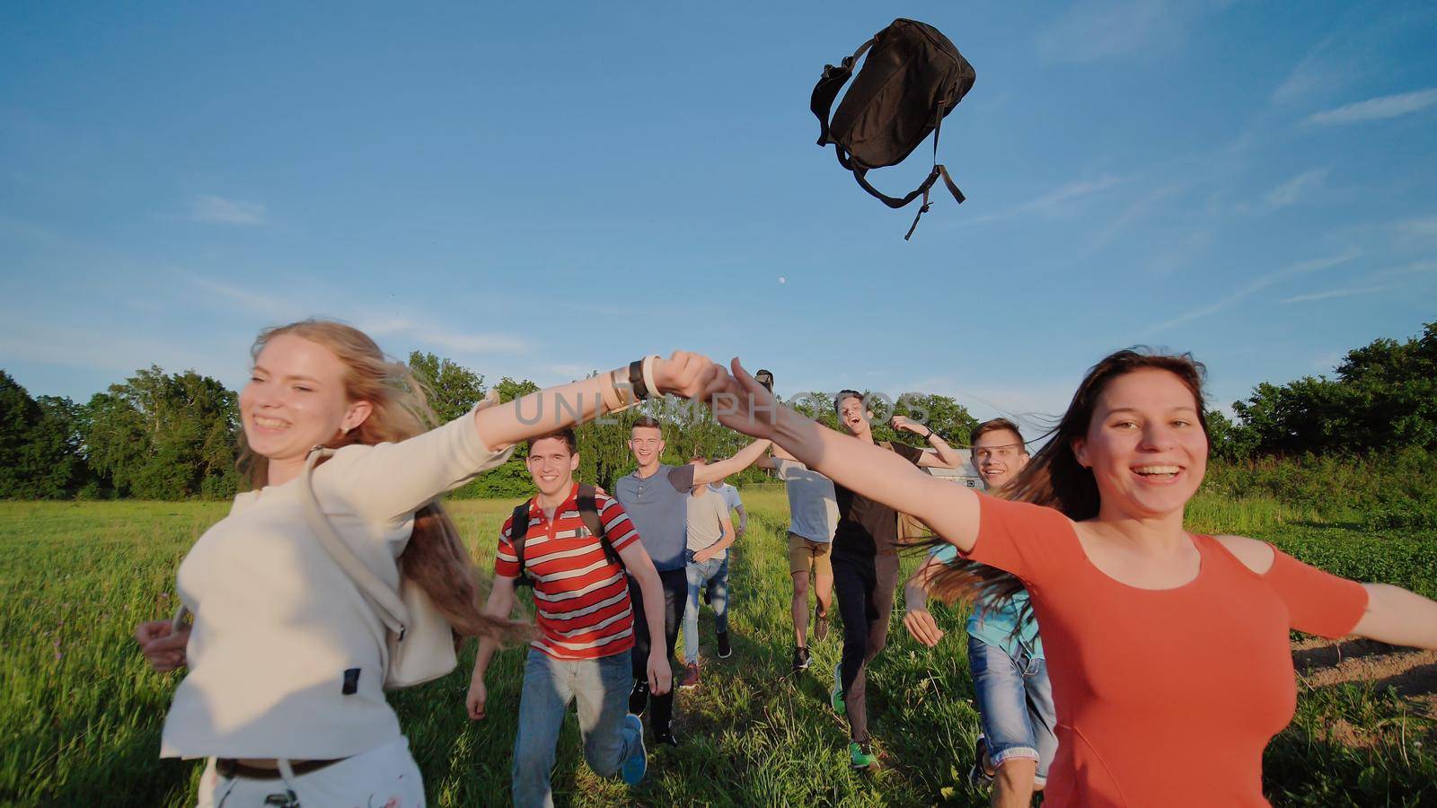 Happy senior pupils flee and toss their portfolios against the sunset. Happy ending school days. Slow motion