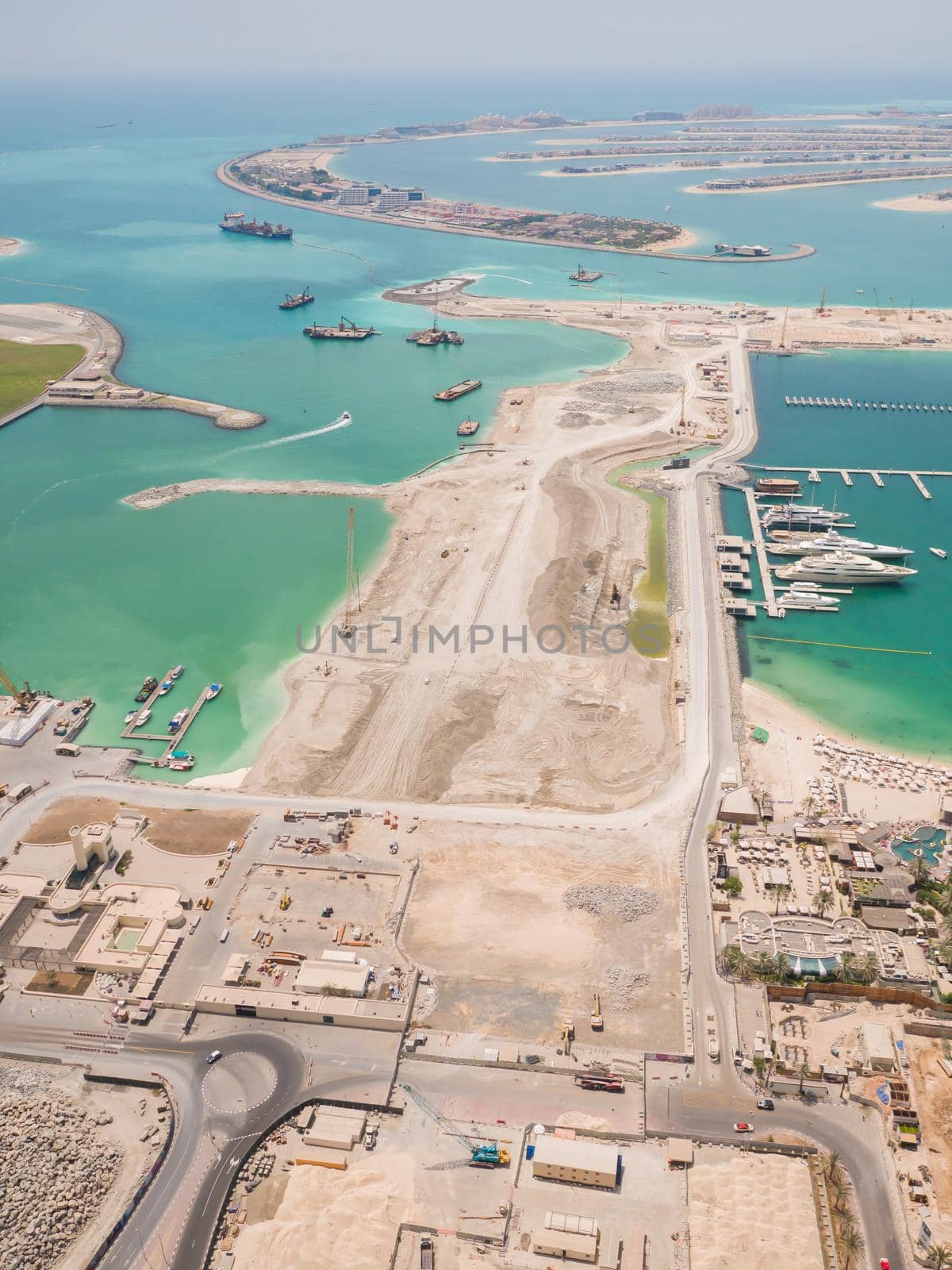 Construction of an artificial island Palm Jumeirah with construction equipment in Dubai