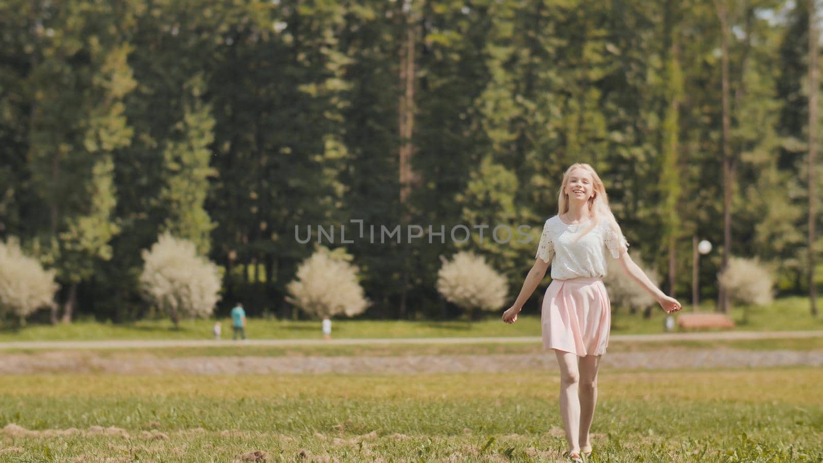 A happy young russian girl is running in the city park
