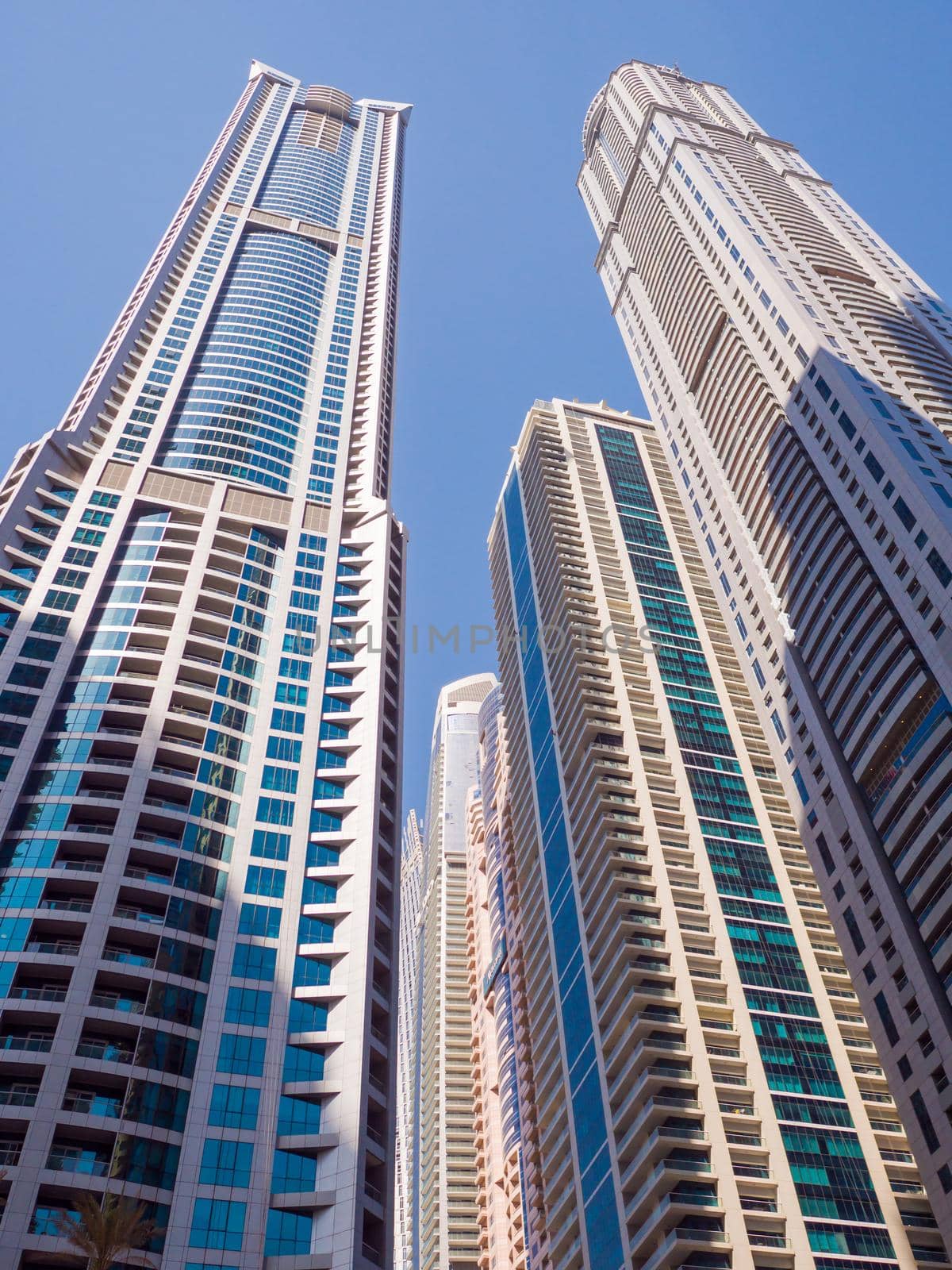 High-rise skyscrapers with blue sky of Dubai city. UAE. by DovidPro
