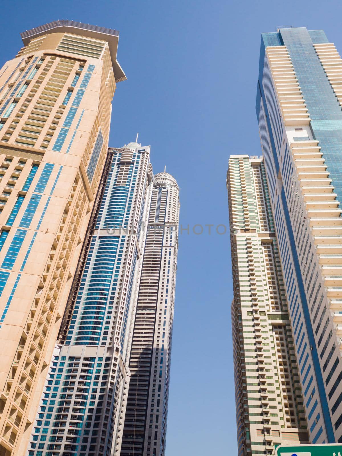 High-rise skyscrapers with blue sky of Dubai city. UAE. by DovidPro