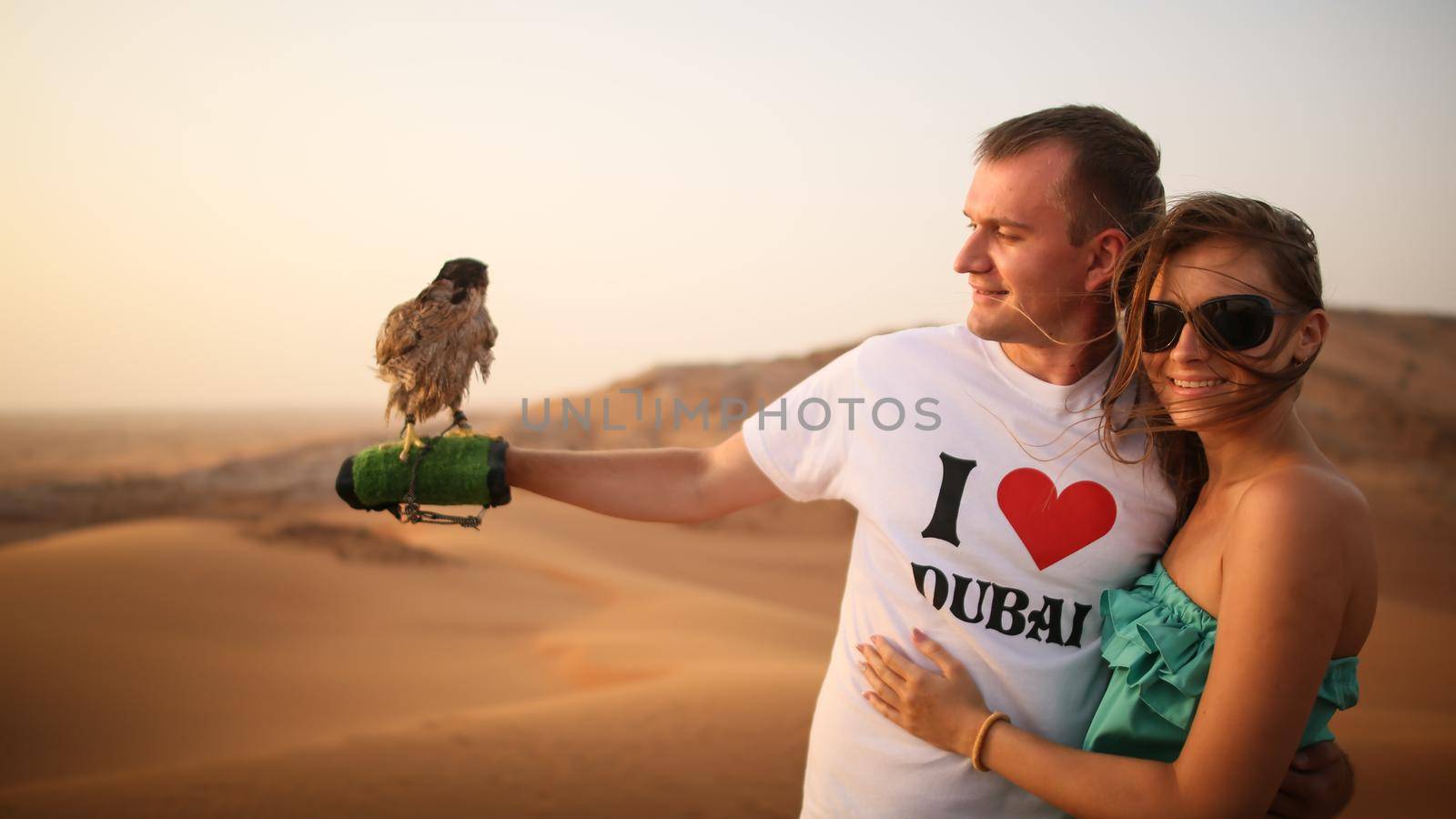 Girl and the guy keep on hand eagle. Desert in Abu Dhabi, United Arab Emirates