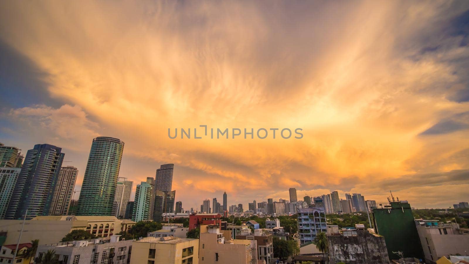 The capital of the Philippines is Manila. Makati city. Beautiful sunset with thunderous powerful clouds. by DovidPro