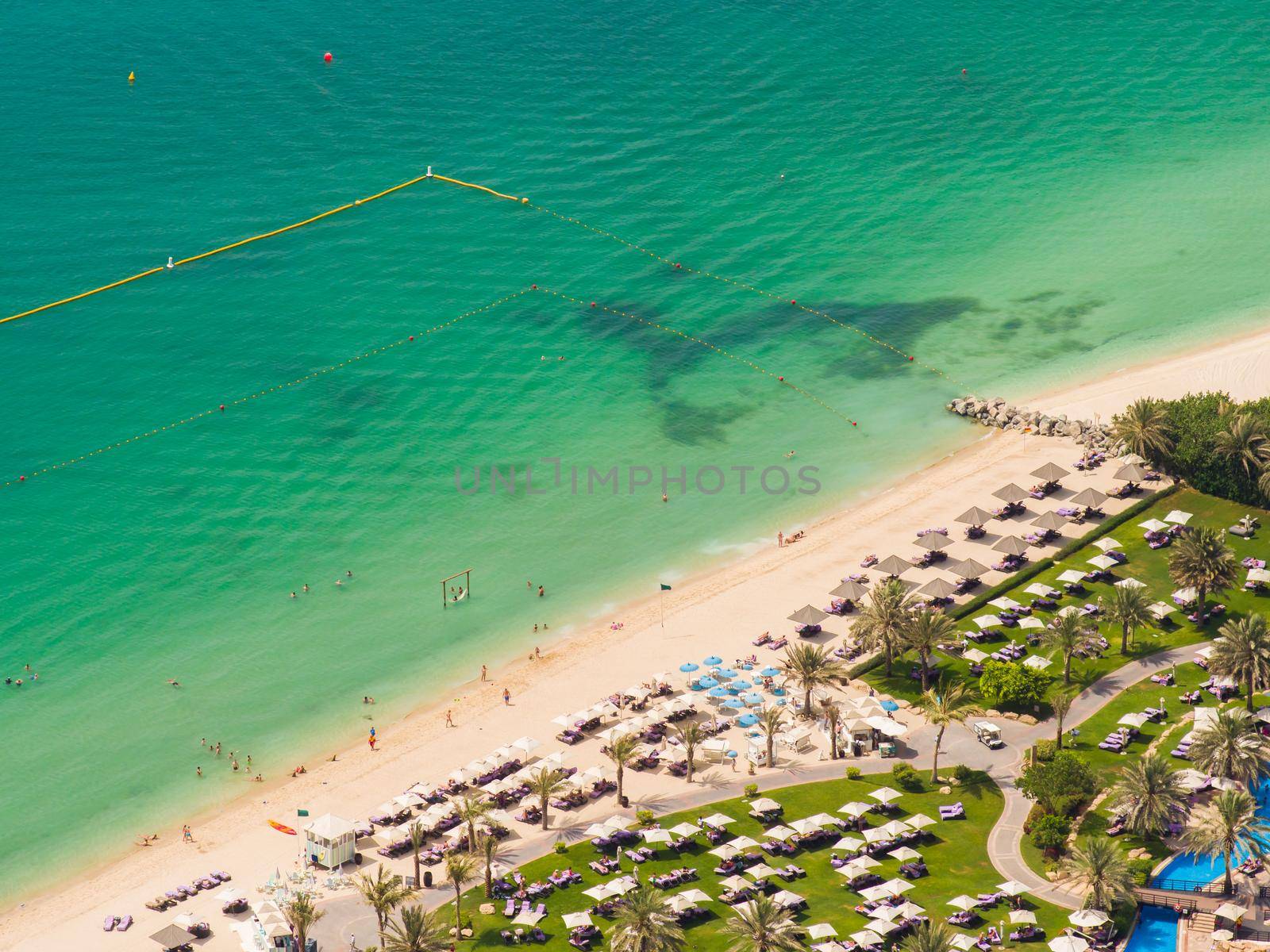 Sunny vacation in Dubai. Beach with tourists. View from a height