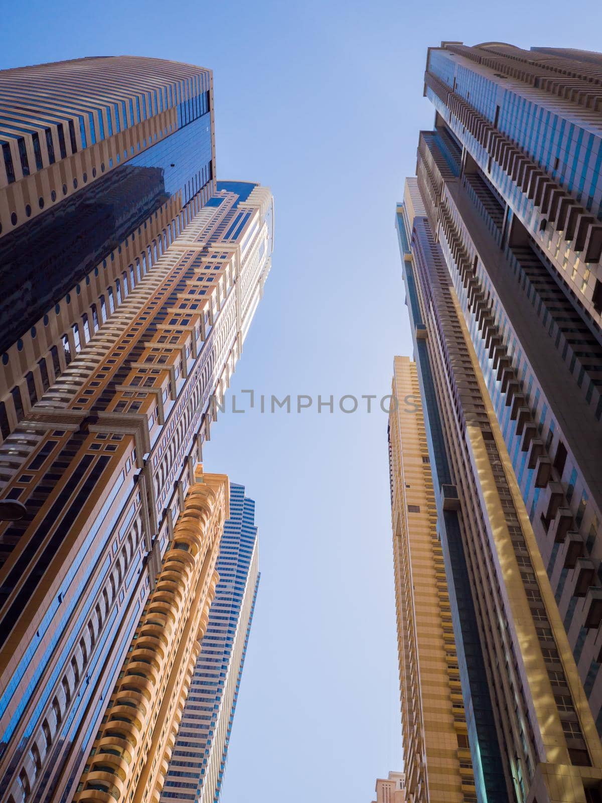 High-rise skyscrapers with blue sky of Dubai city. UAE. by DovidPro