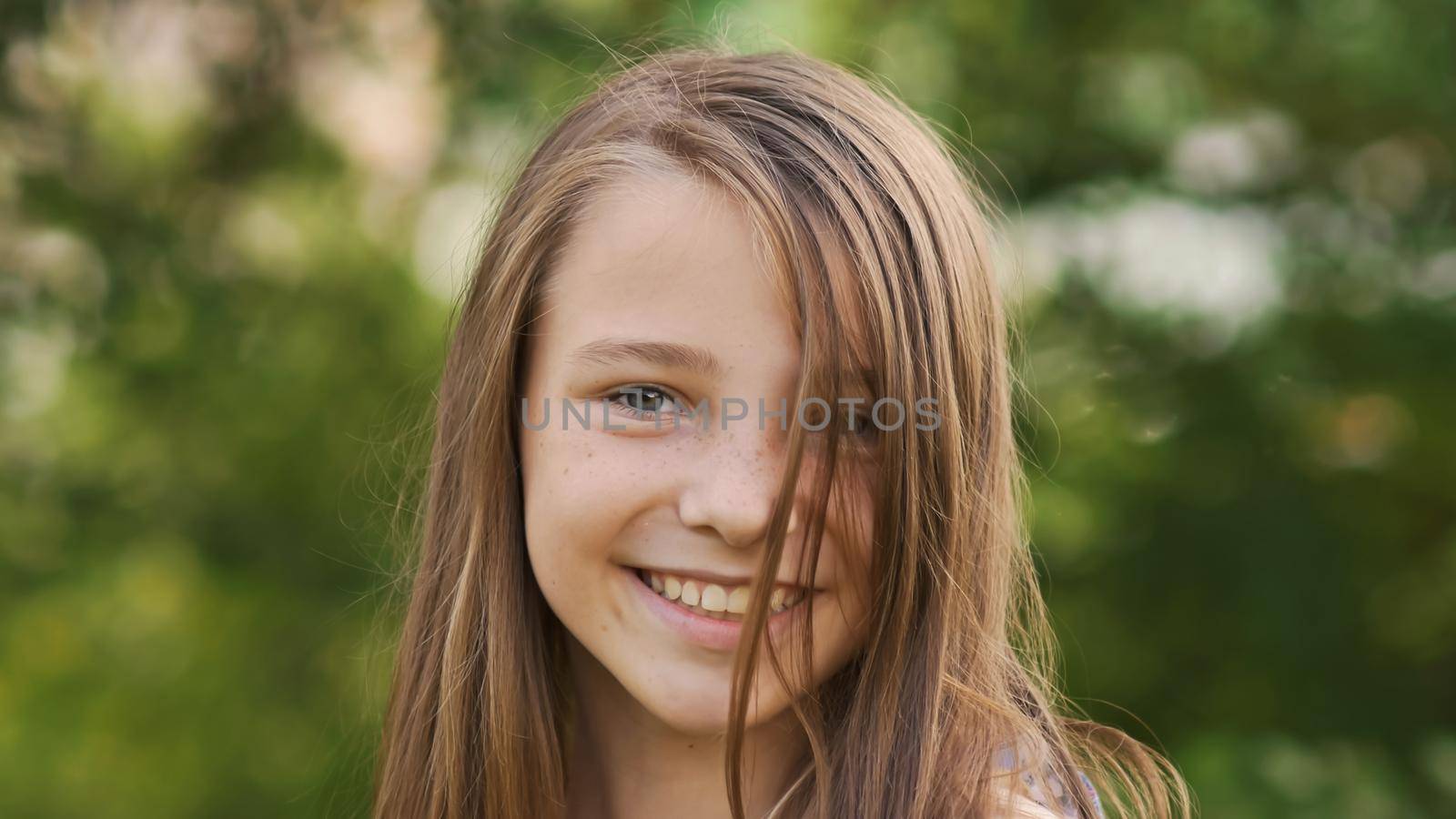 Girl teenager face close-up with freckles and funny posing embarrassed and playing with his hair