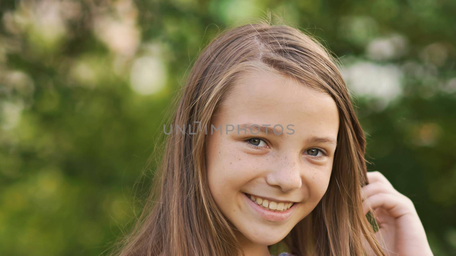 Girl teenager face close-up with freckles and funny posing embarrassed and playing with his hair