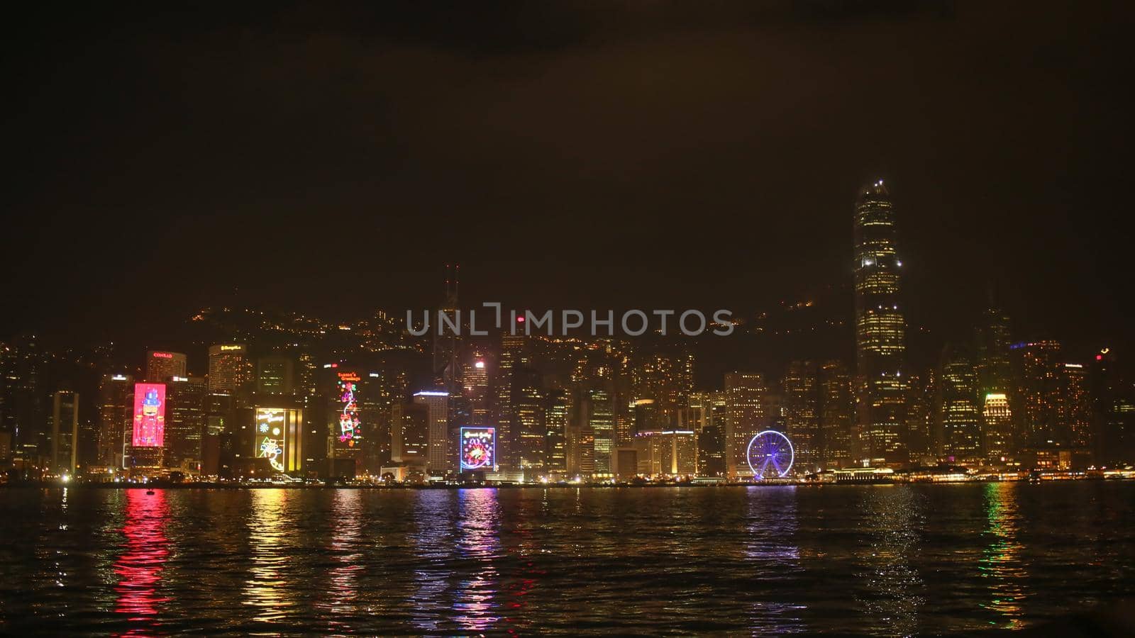 City of Hong Kong at night. Multicolored lights illuminating buildings in the reflection of the sea. Beautiful city view
